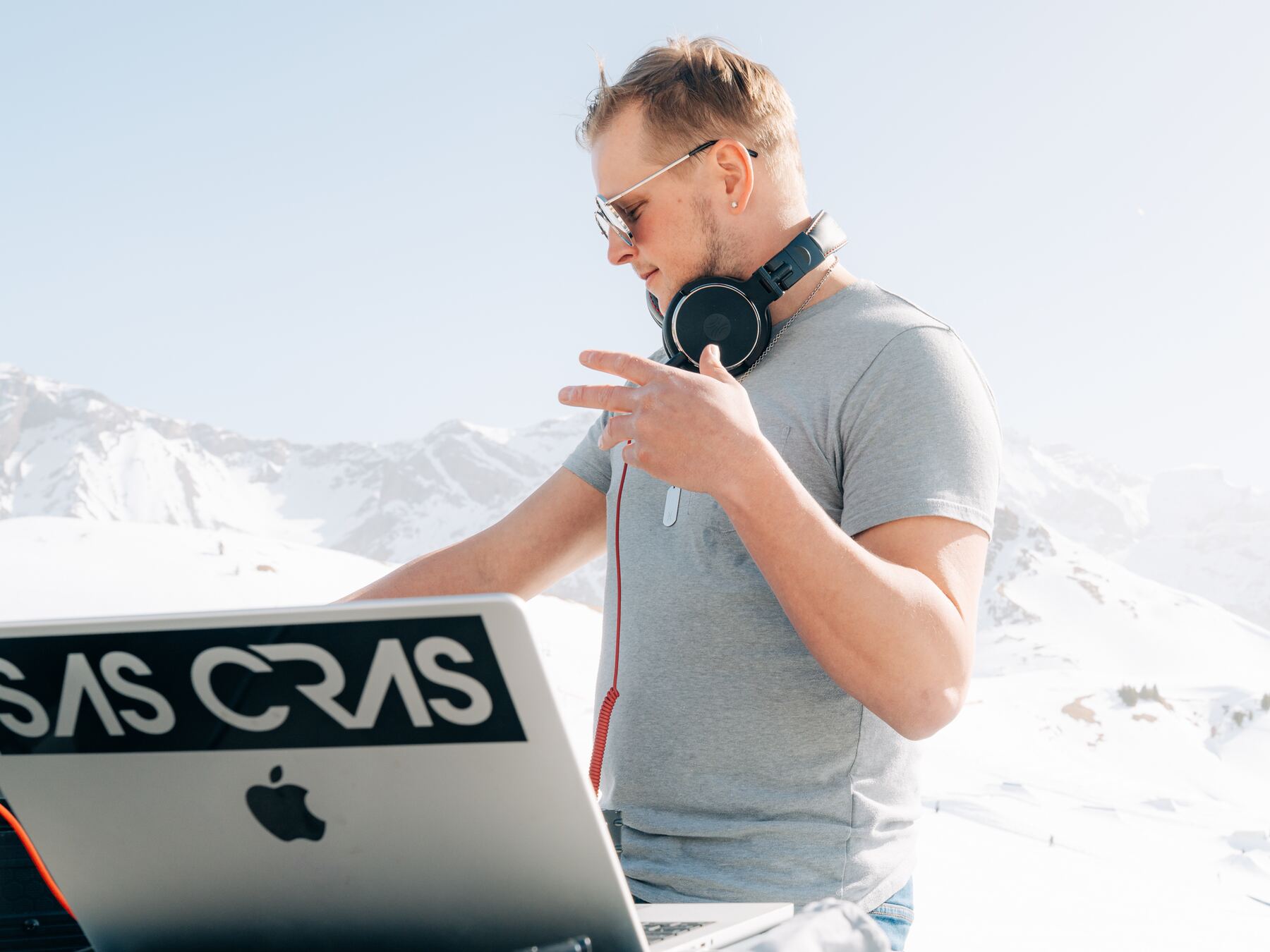 Sas Cras playing a set outdoors in the snow, mountains behind