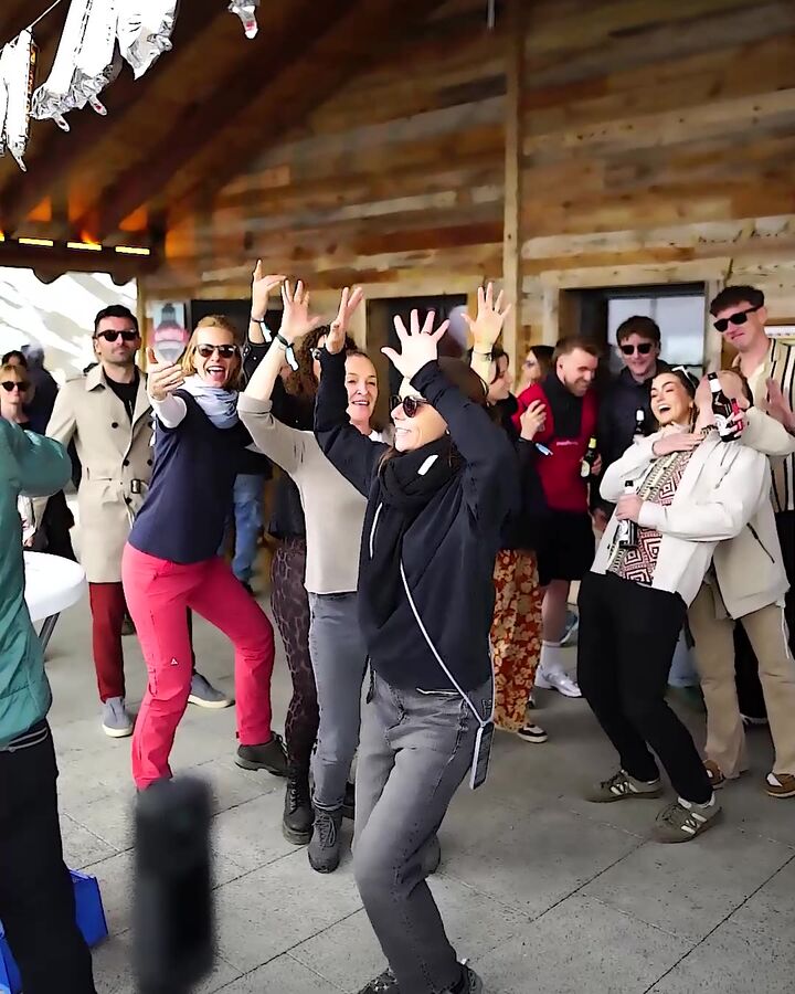 Crowd dancing with raised arms on the terrace at Tschentenalp